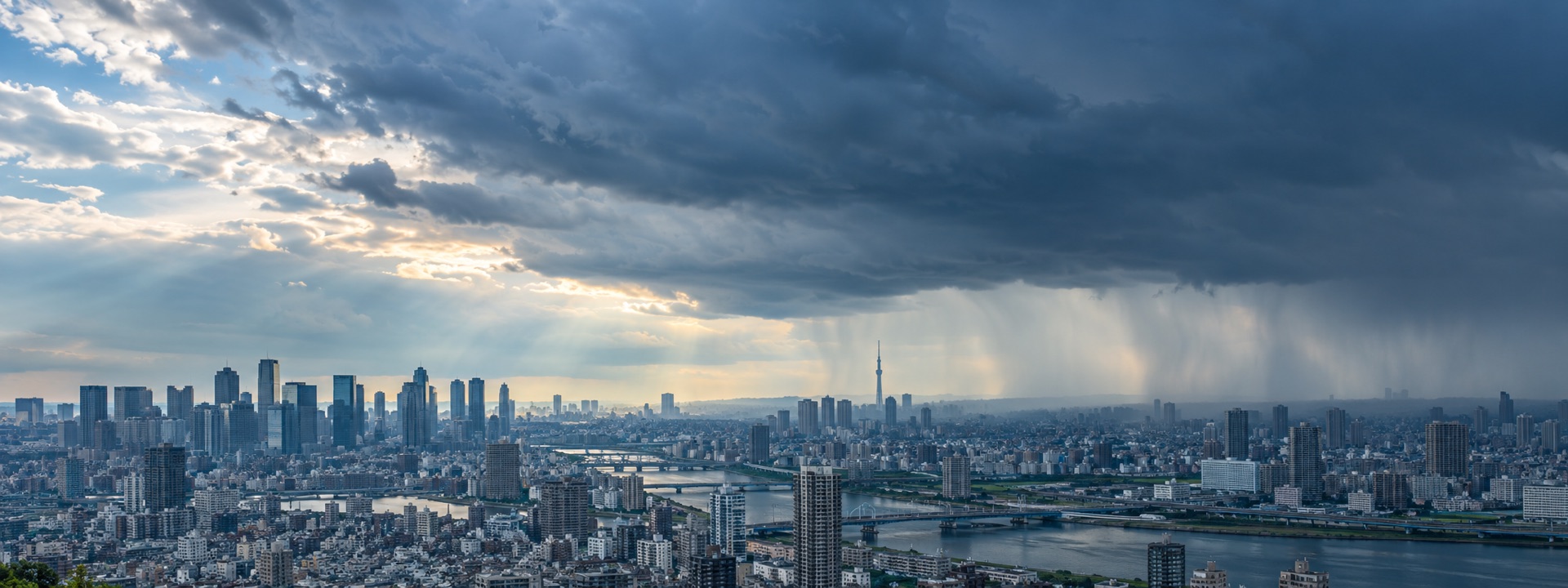 雨雲と光が広がる東京の街並み